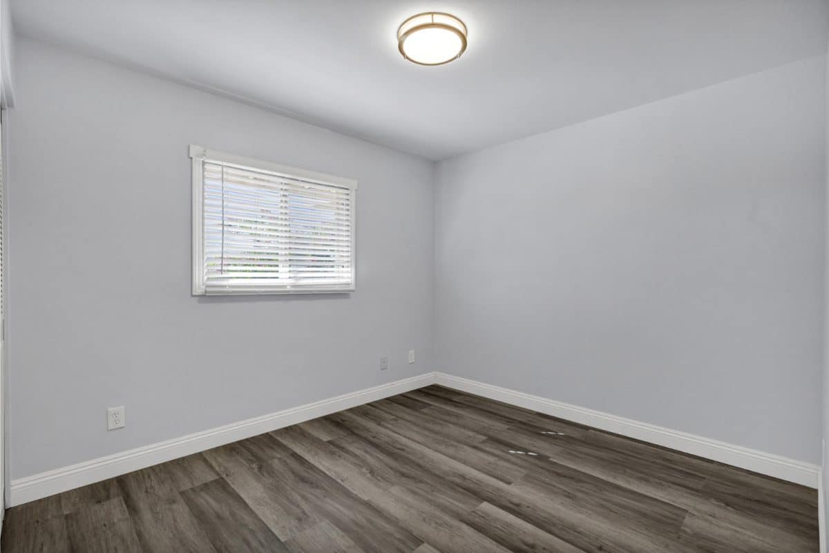 Bedroom 3 with LVP flooring and window blinds at 14 E Hermosa Dr